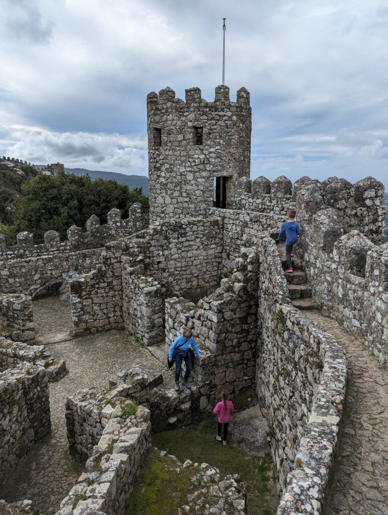 Several people on different levels of stone castle ruins in Sintra, Portugal