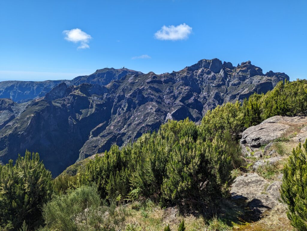 Rugged mountains with green shrubs and rocks in the foreground