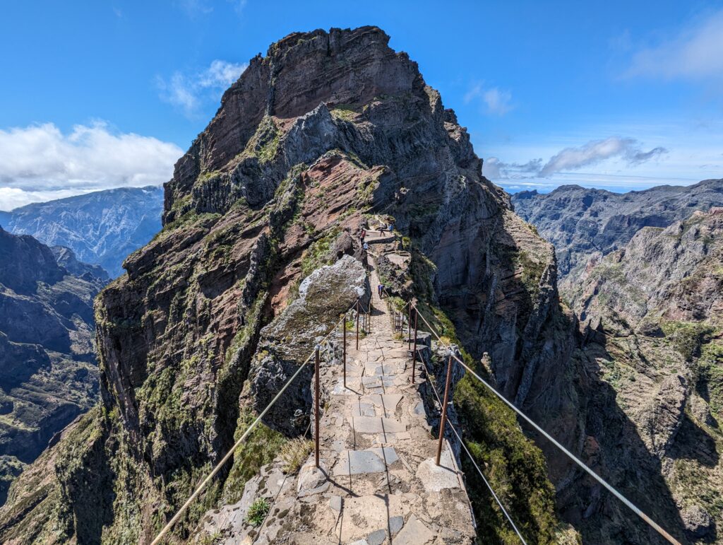 A narrow path with wires leading to a mountain peak on Madeira, Portugal