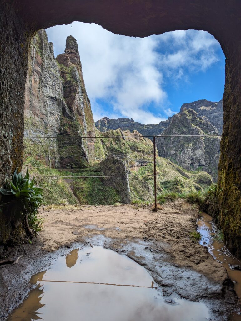 Looking out a tunnel at lush mountains