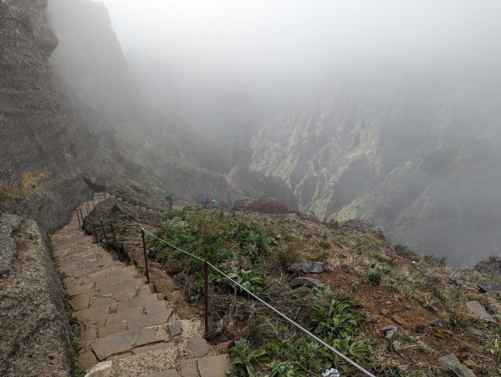 A stone staircase leading down with the background obscured by clouds