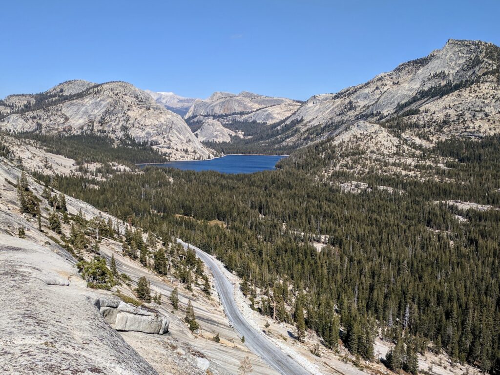 An aerial view of Tenaya Lake surrounded by trees and mountains from Olmsted Point