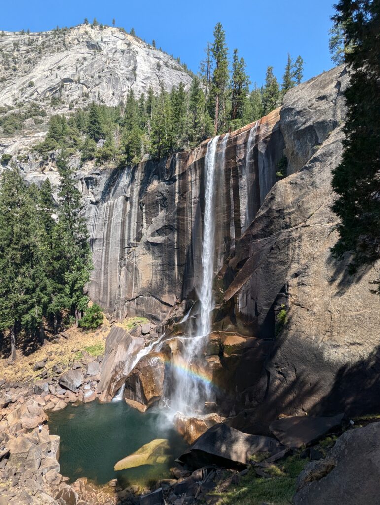 A waterfall with a rainbow at the bottom 