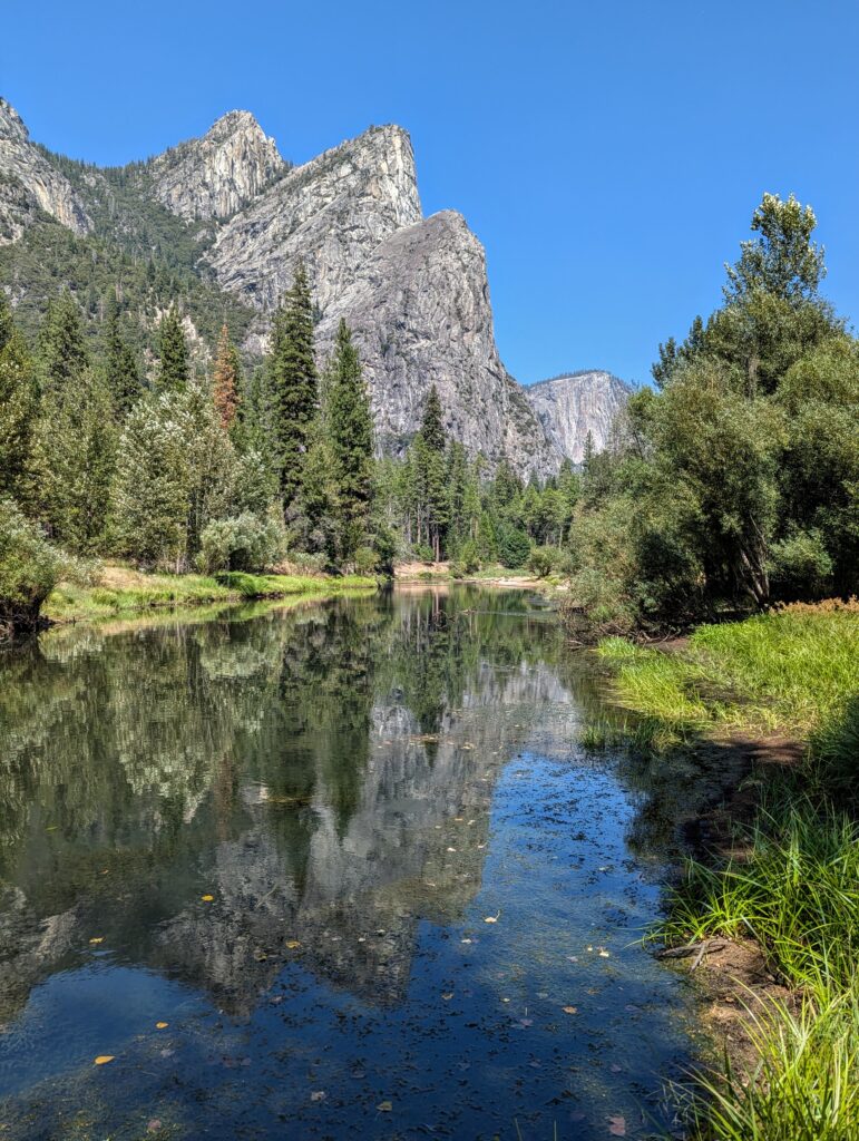 The 3 Brothers mountain peaks reflected in a body of water