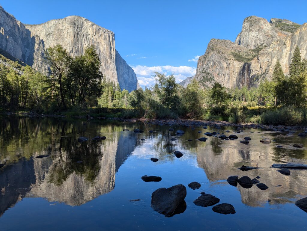 Mountains are split by open sky in the middle with everything reflected in a body of water