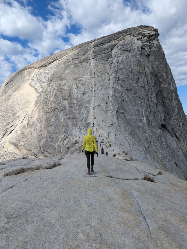 A hiker approaches a very steep Half Dome in Yosemite