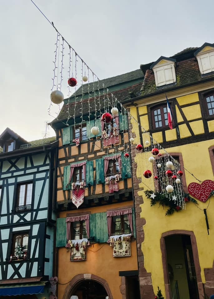 Christmas decorations strung high above a street in Riquewihr