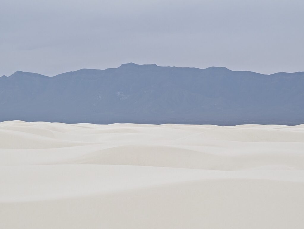 An abstract view of white sand dunes and obscured mountains at White Sands National Park
